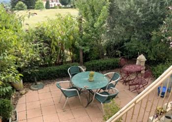 FR : Depuis la véranda de la cuisine, la vue plongeante sur l’écrin de verdure du jardinet est très agréable. EN : From the kitchen veranda, the sweeping view over the verdant setting of the small garden is very pleasant.